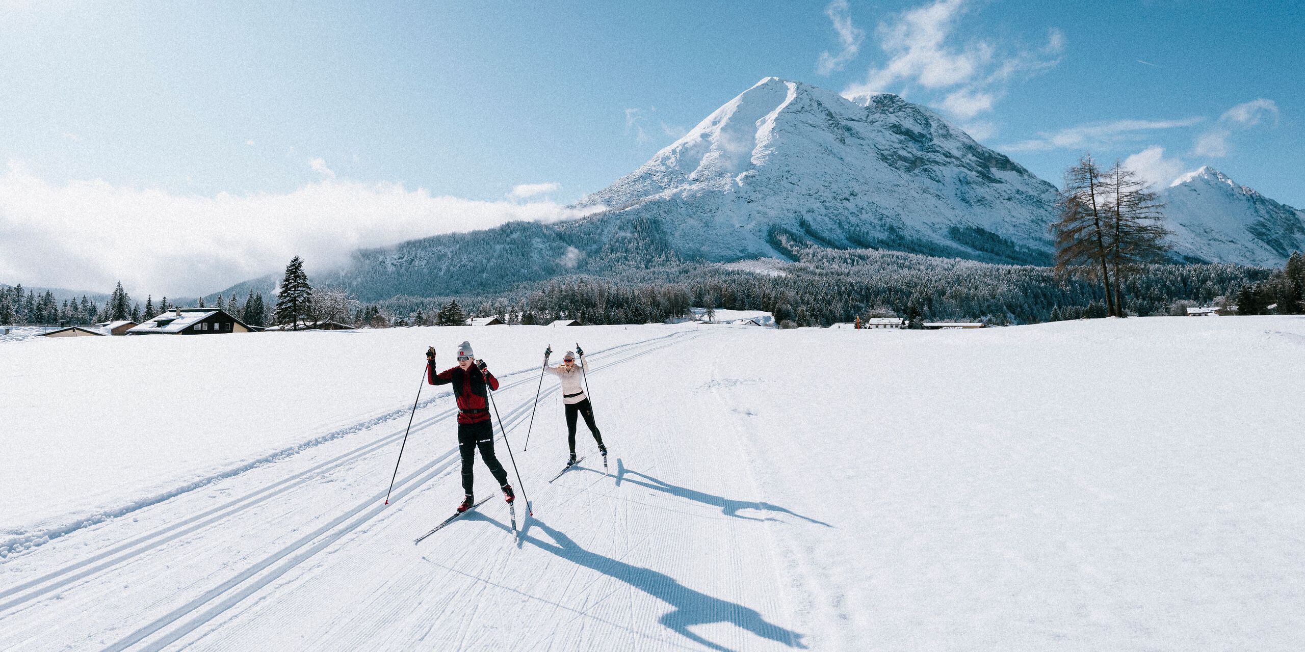 Langlaufen in der Region Seefeld_zwei Langläufer auf C9 Plaik Loipe in Leutasch_Weitwinkelaufnahme mit Hohe Munde